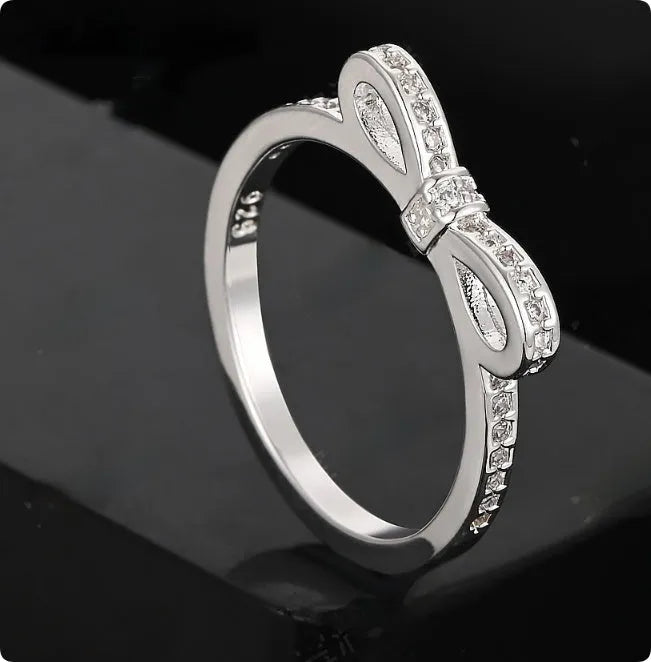 Silver electroplated ring with a bow shape design set with rhinestones and zircon crystals.