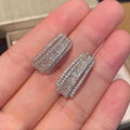 A pair of geometric shaped stud earrings with inlaid zircon stones in a white gold colour finish.