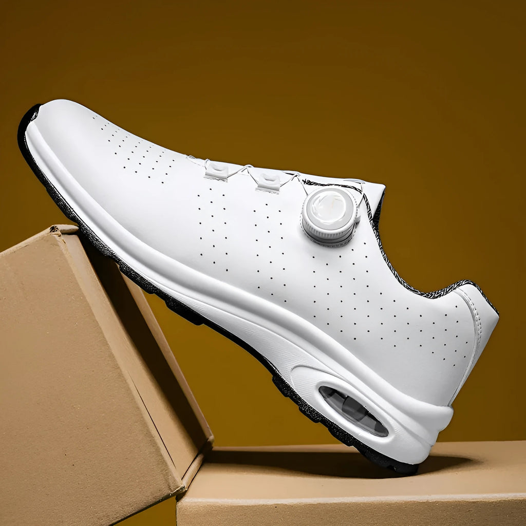 Black and white low-top casual tennis shoes with mesh upper, cross shoulder straps, and flat composite sole.