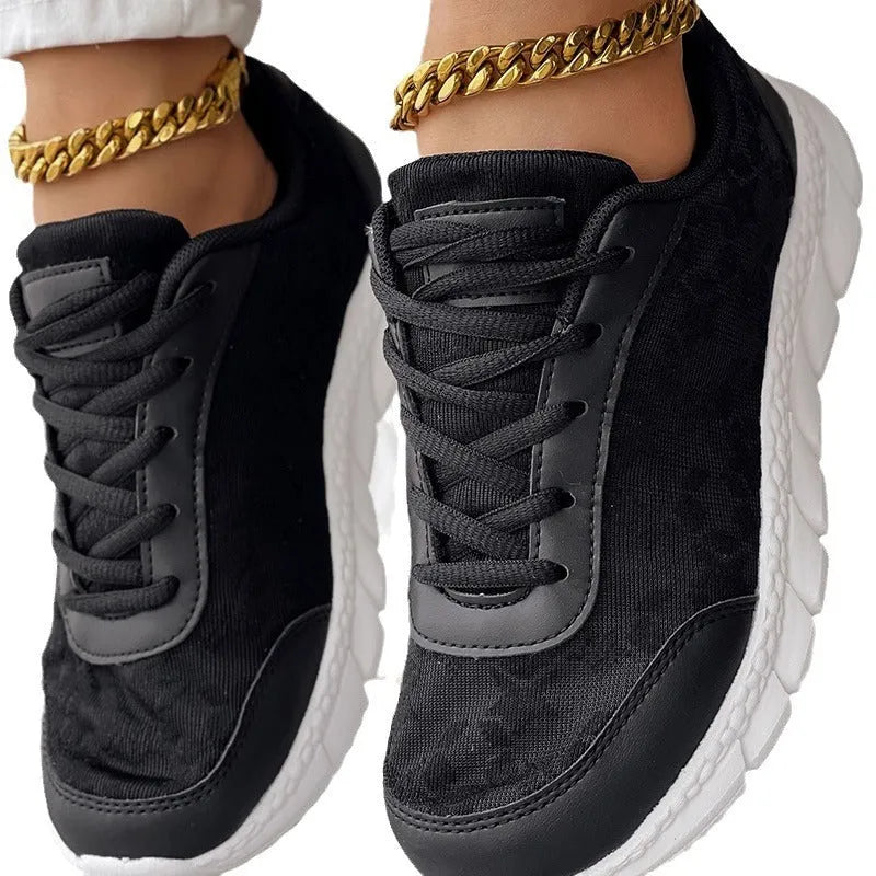 Women's white canvas running shoes with a flat sole and round toe on a neutral background.