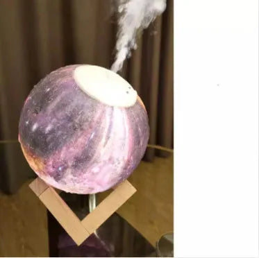 Wood coloured spherical Lunar humidifier night light on a bedside table emitting mist and soft white light.