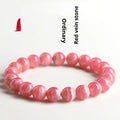 Women's geometric red rhodochrosite crystal bracelet with a longevity lock clasp on a wrist.