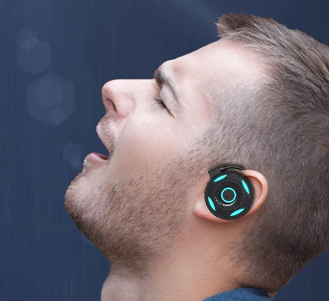 Black and white wireless gaming earphones with hanging ear design and USB charging cable