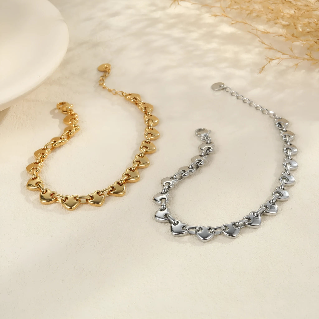 Women's hollowed-out heart bracelet in stainless steel with gold, steel, or colour block electroplated finish.