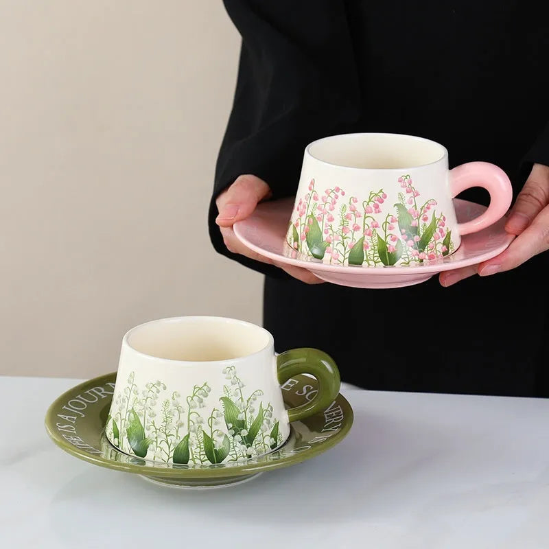 Ceramic coffee cup and saucer set for couples with stirring spoons in two pattern choices.