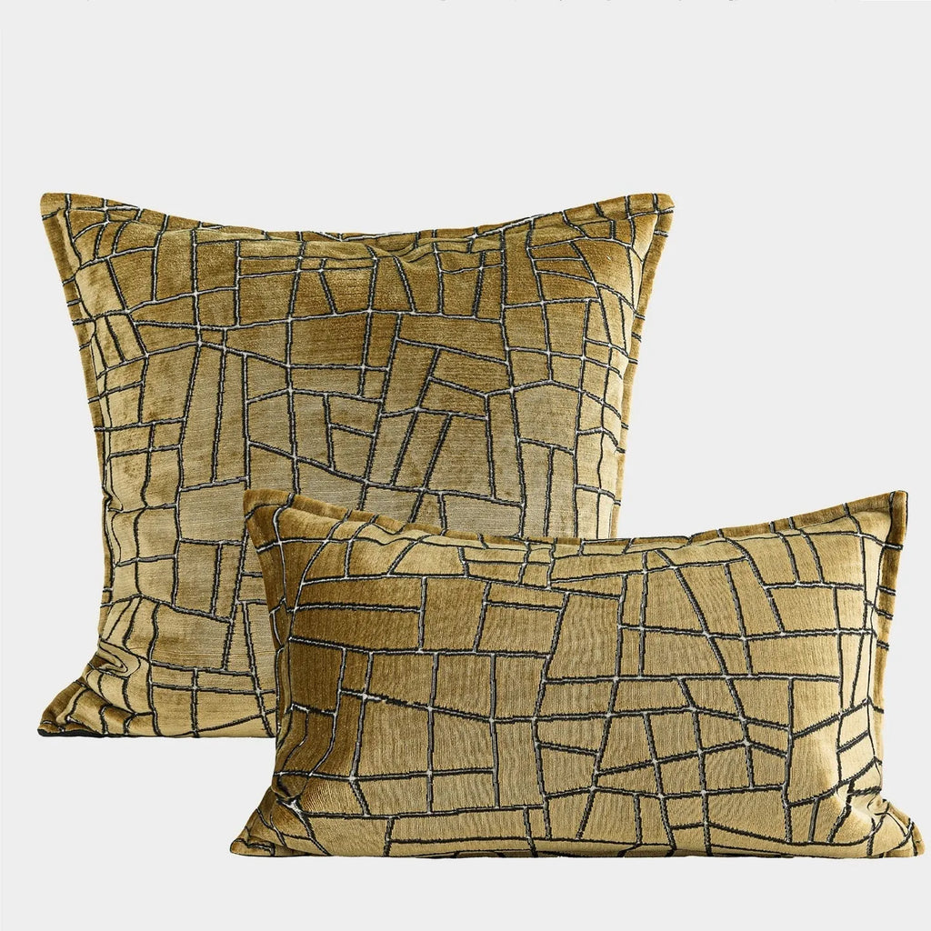 Gold geometric pattern decorative cushion cover on a grey sofa