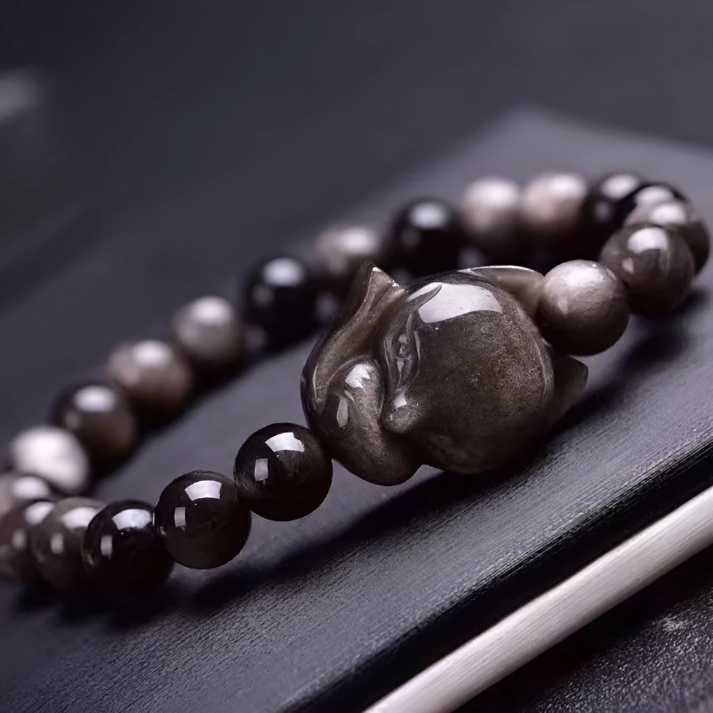 Obsidian fox charm bracelet with 8mm polished stone pendant on a black elastic cord.