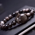 Obsidian fox charm bracelet with 8mm polished stone pendant on a black elastic cord.