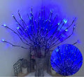 25cm tall LED decorative tree light in a vase with colourful silver branches illuminated.