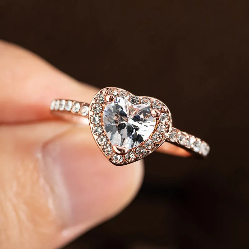 Women's heart-shaped crystal ring in rose gold or silver tone on a white background