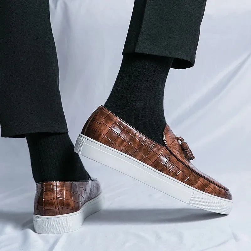 Men's black slip-on sneakers with tassel detail on the vamp and a round toe.