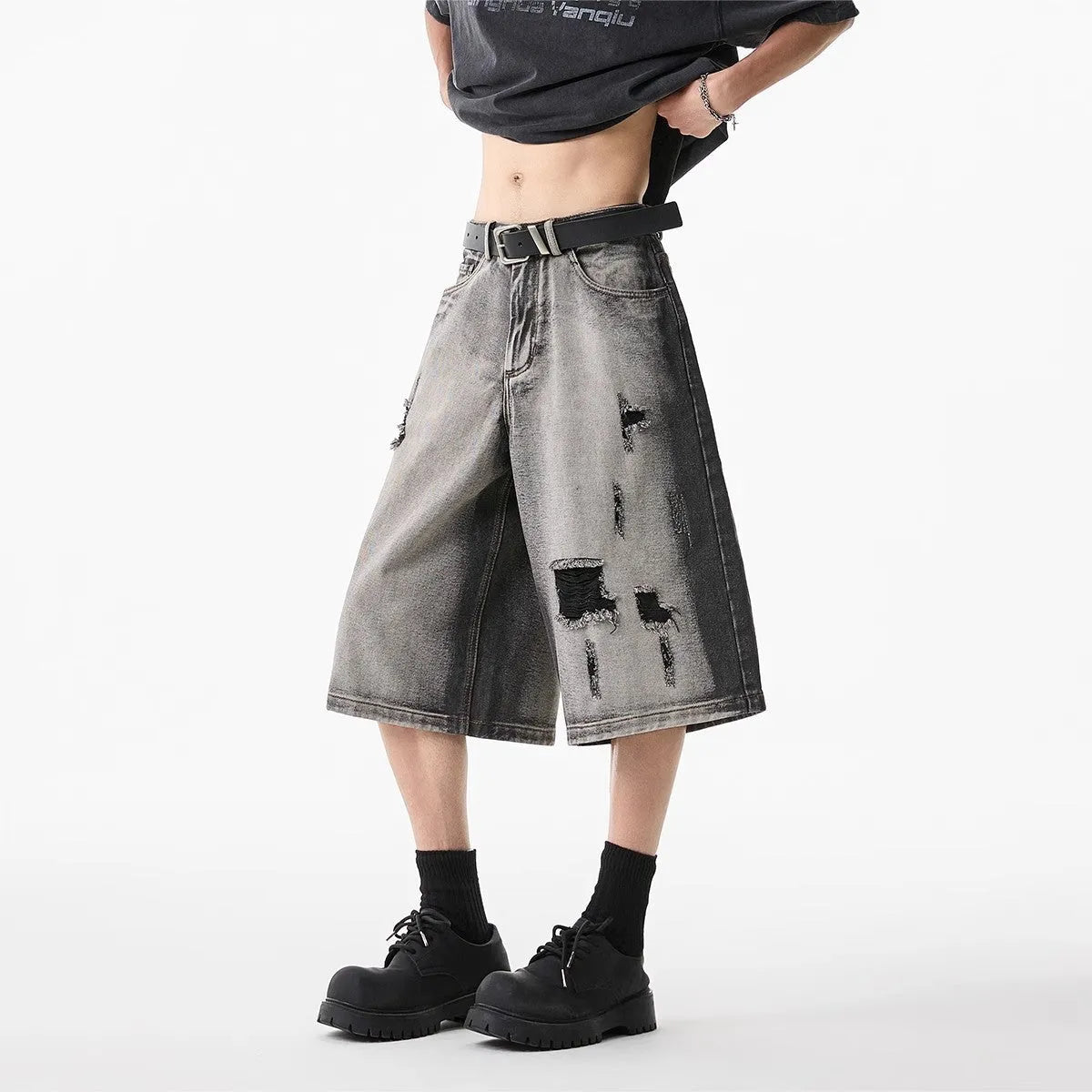 Grey high street washed cotton denim shorts with a loose, cropped fit on a hanger.