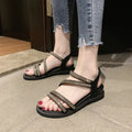 Women's silver flat sandals with rhinestone decoration and elastic band, showing the round toe and rubber sole.