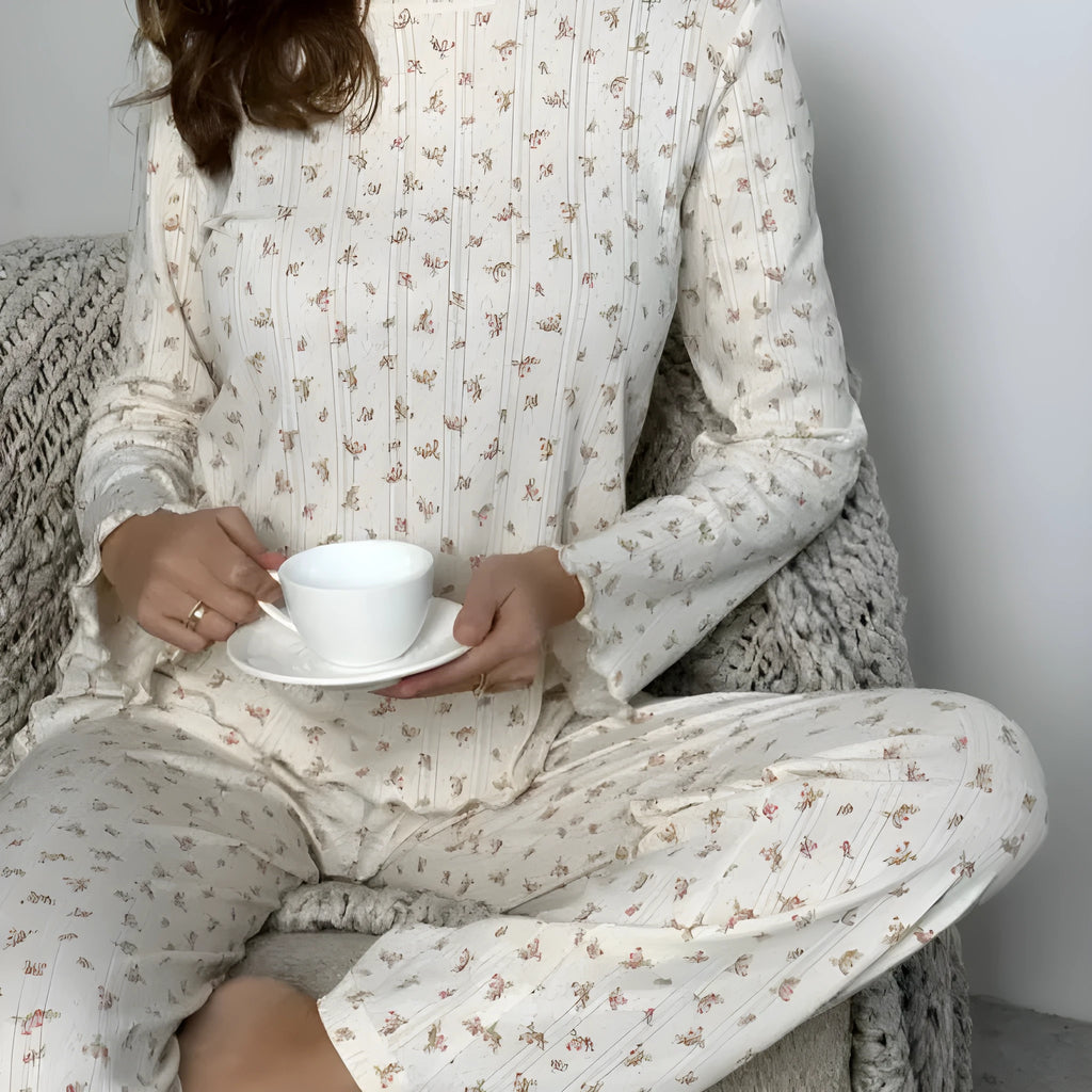 White women's floral print polyester two-piece suit with bell sleeve top and wide-leg trousers.