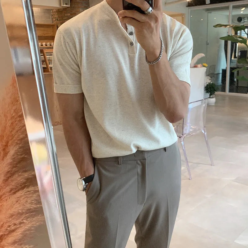 Man wearing a thin black loose-fit knitted short-sleeved pullover shirt.