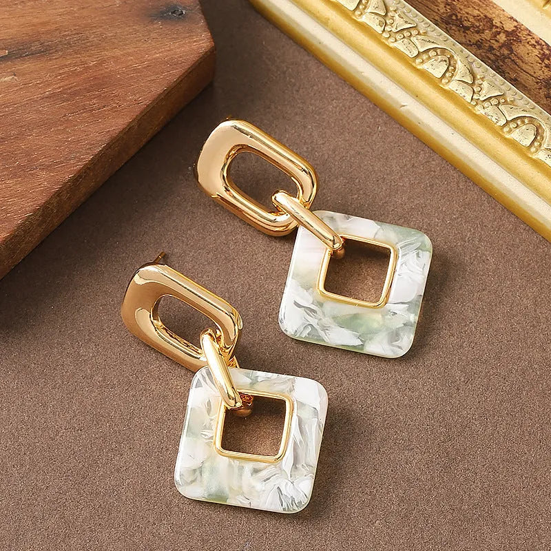 A pair of hollow geometric square earrings with chamfered corners, made from electroplated copper.