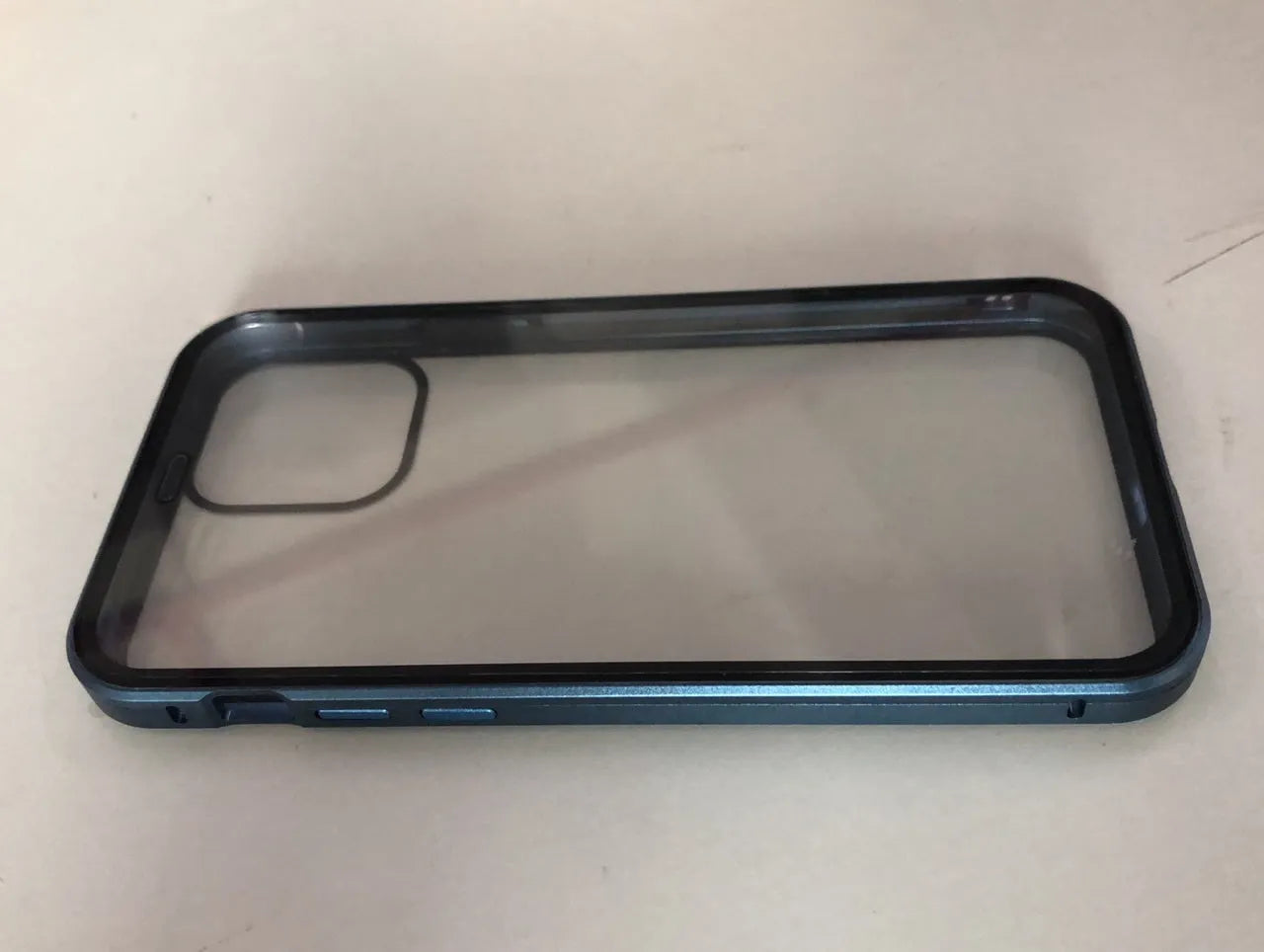 Geometric patterned glass clamshell privacy case for iPhone on a table.
