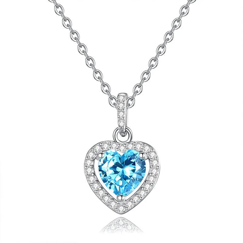 Heart-shaped sterling silver necklace with a round amethyst gemstone on a cross chain.