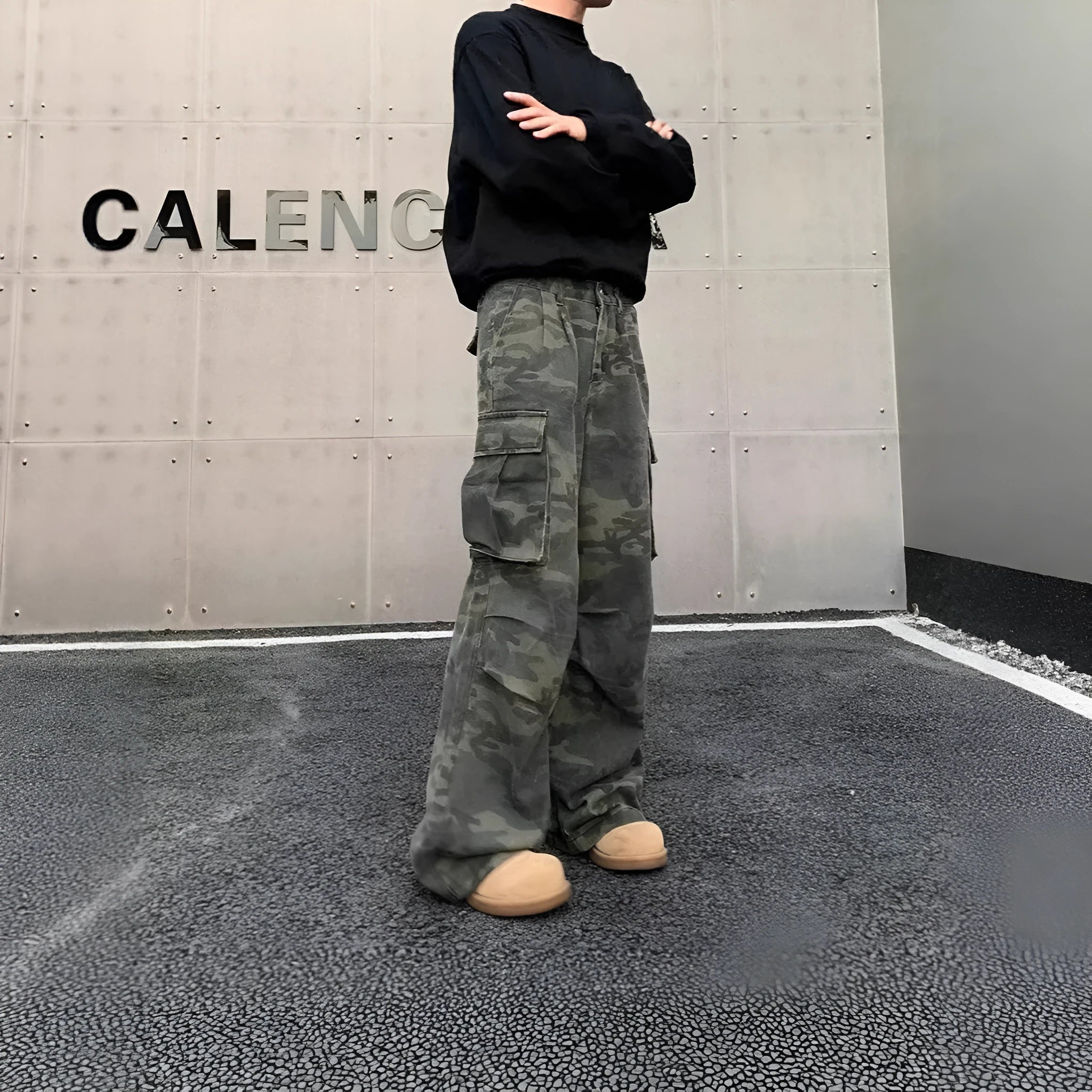A pair of washed camouflage cotton blend cargo trousers with multiple pockets on a mannequin.