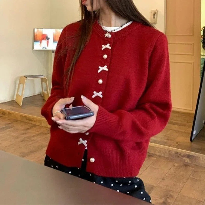 Women's solid colour cardigan with a bow and pearl buttons, shown in a light colour.