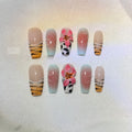 Zebra pattern and Lily hand carving design on a set of long, decorative false nails.
