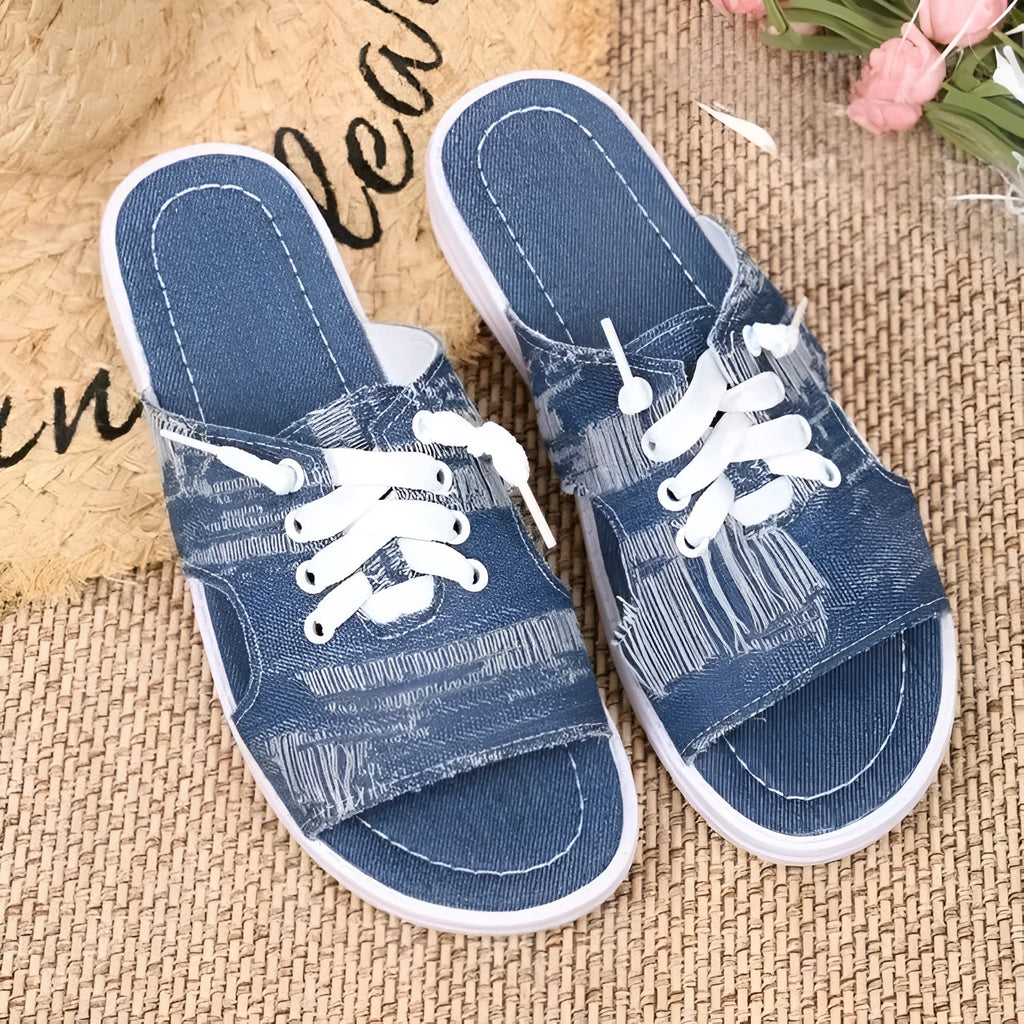 Blue Roman-style women's flat canvas slippers with cloth upper and rubber sole.