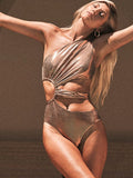 Women's solid gold backless one-piece swimsuit on a model.