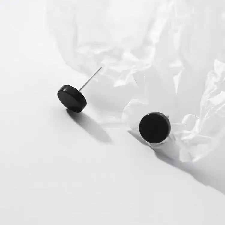 A pair of simple round flat-front sterling silver S999 ear bone stud earrings on a plain background.