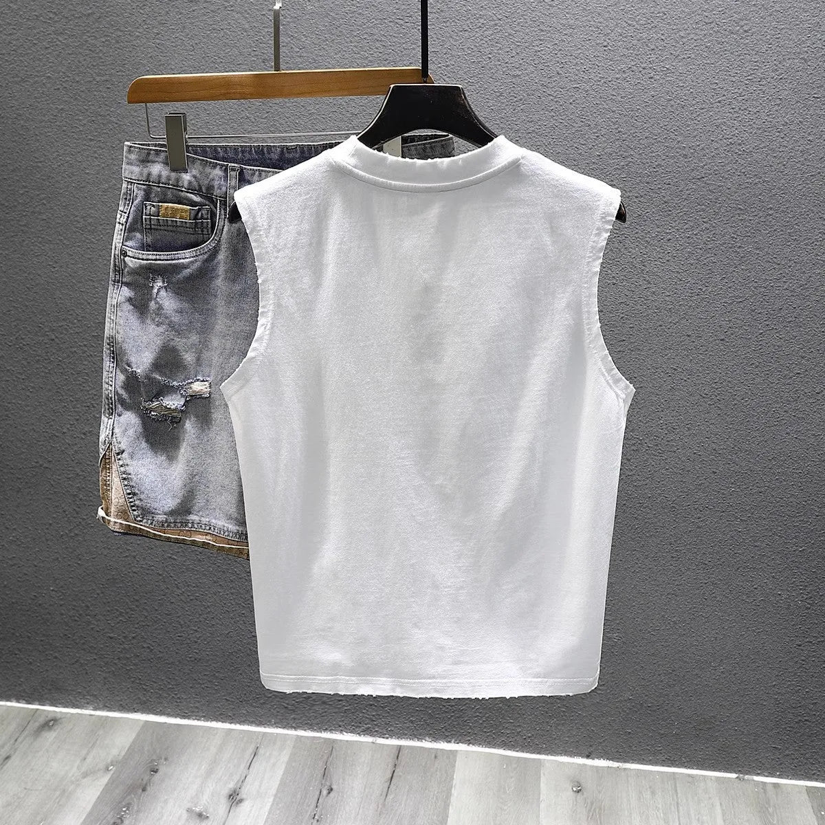 A man's solid colour loose-fit cotton sleeveless t-shirt with a straight hem.