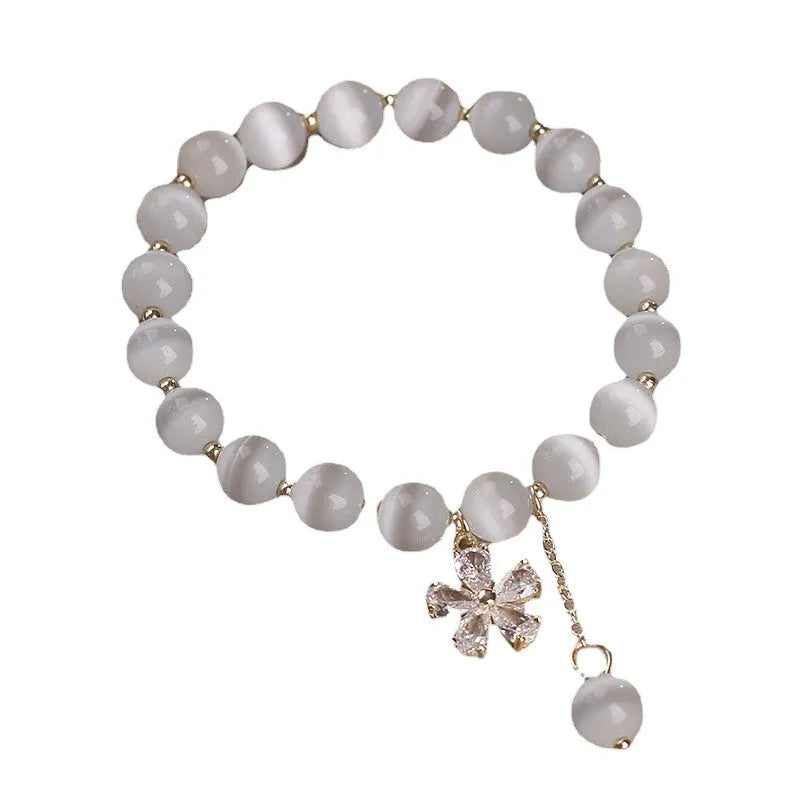 White cat's eye stone women's bracelet with safety buckle pendant and flower tassel detailing