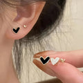 Three pairs of heart-shaped earrings in gold, black, pink, and black white colours with love-themed girly styling