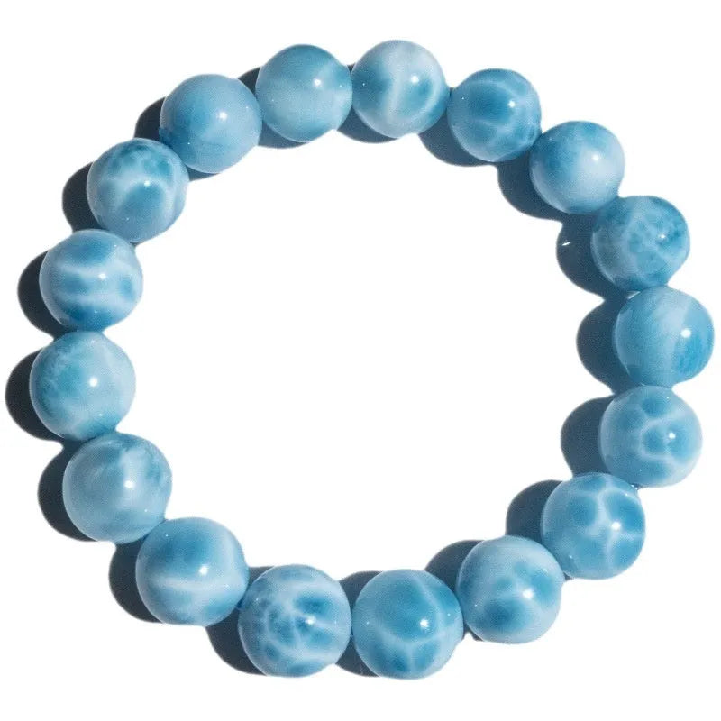 Blue Maillard-style bracelet with bodhi beads, natural crystal stone, and pearl accents on a wrist.