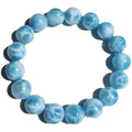 Blue Maillard-style bracelet with bodhi beads, natural crystal stone, and pearl accents on a wrist.
