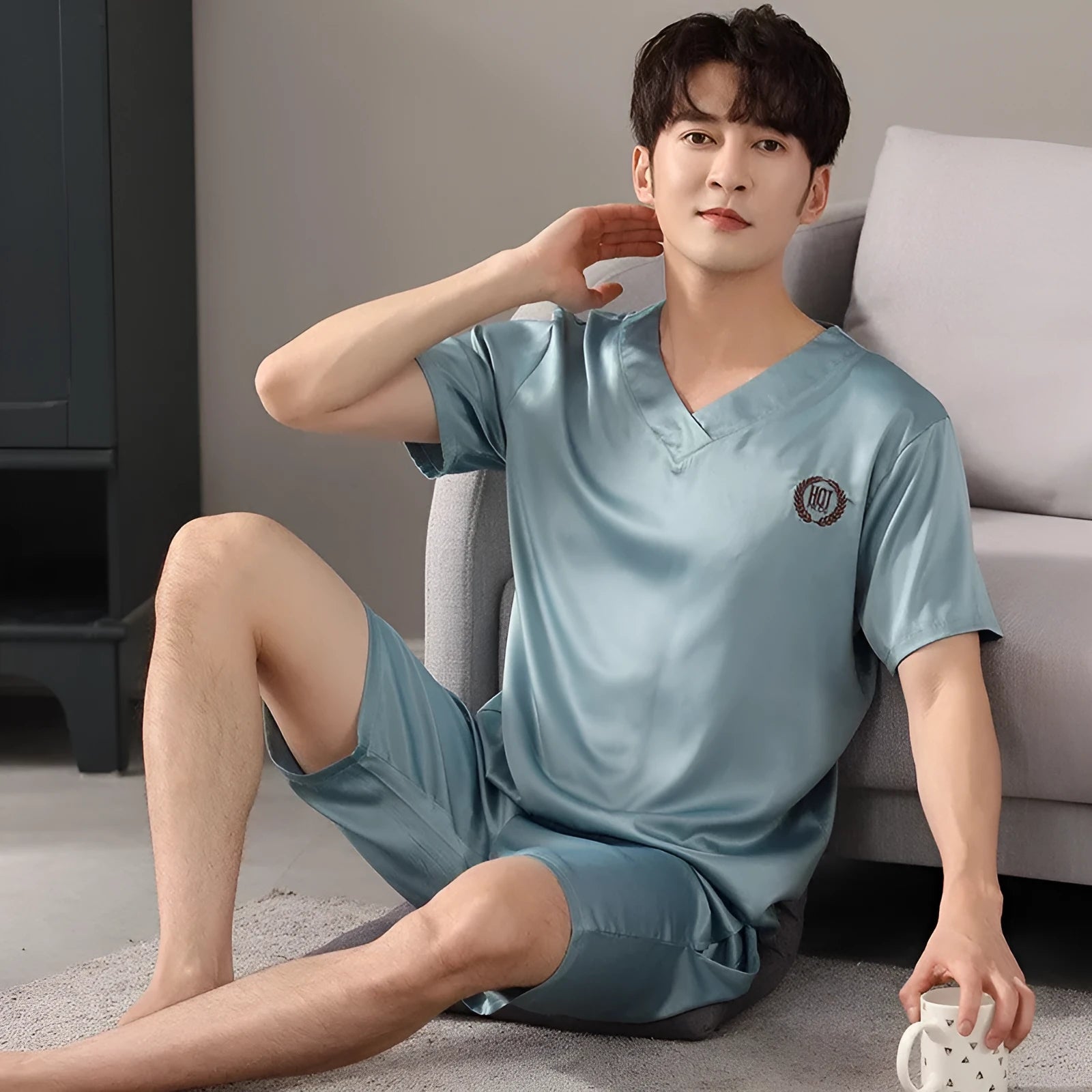 Man wearing a loose light blue short-sleeved ice silk pajama shirt and matching shorts.