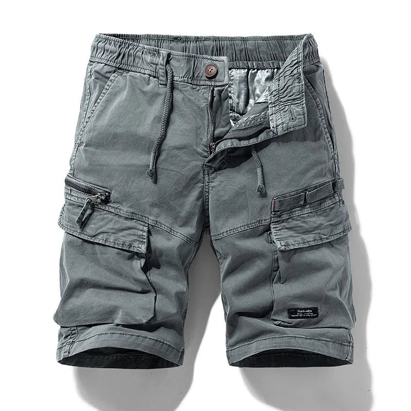 Men's army green cotton shorts with multiple zipper pockets and a Korean style design on a hanger.