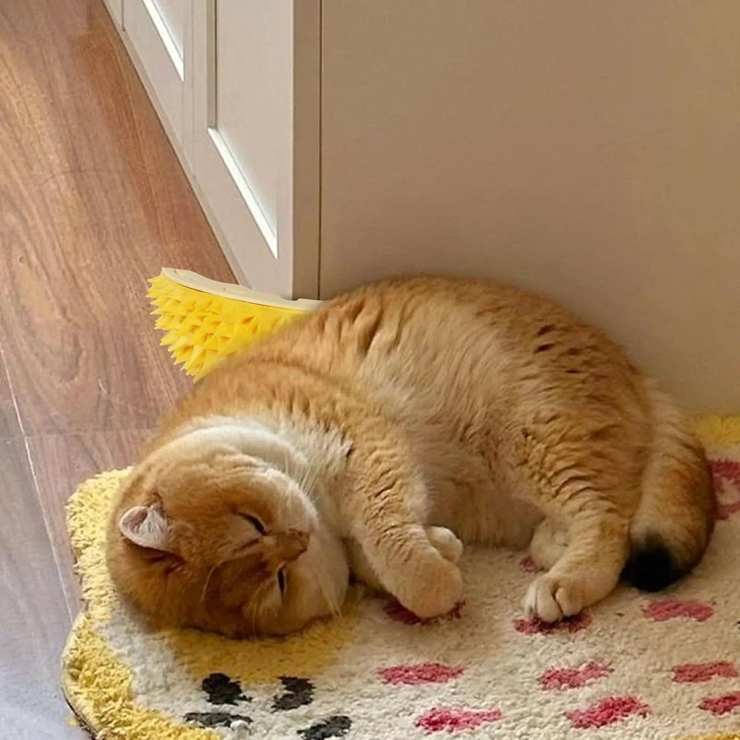 Yellow durian-shaped cat corner scratcher and massage comb with cat mint powder on a wall corner.