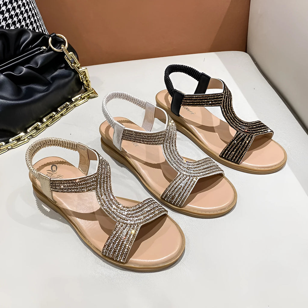 Gold women's patent leather beach sandals with rhinestones on the strap and a round toe.