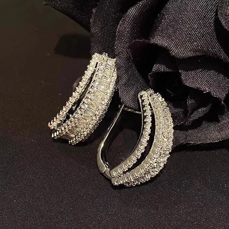A pair of geometric shaped stud earrings with inlaid zircon stones in a white gold colour finish.