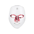 Rechargeable manual touch LED beauty mask in white with gold rim, showing charging cable and strap.