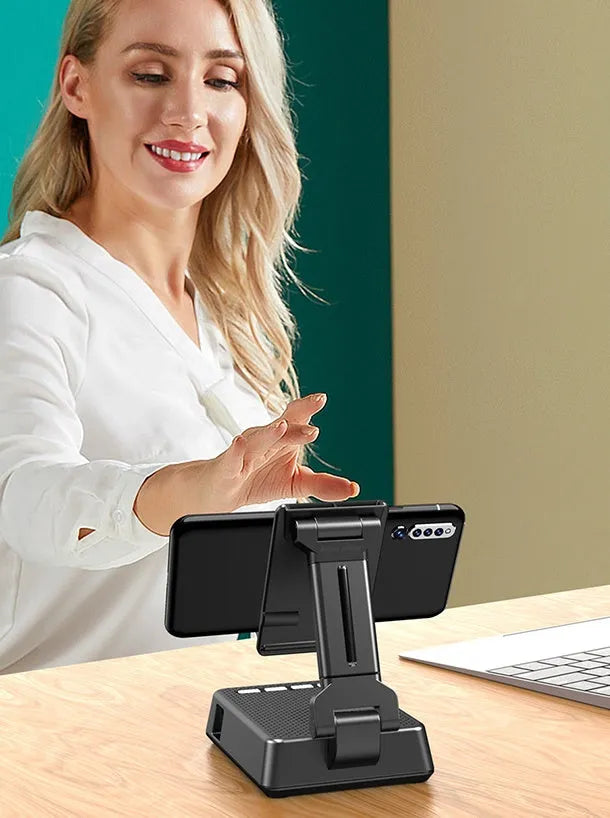Black mobile phone broadcaster stand with Bluetooth speaker and microphone on desk