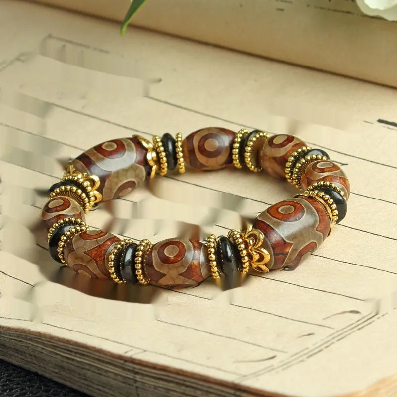 Distressed agate Tibet bead bracelet with three-eye motifs and multiple traditional bead styles on wrist