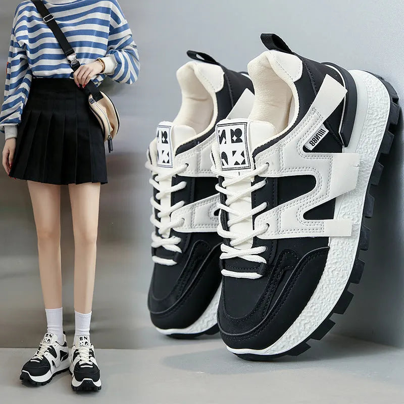 A pair of solid-colour low-top sneakers with a round toe and front lace-up, shown in white or black.