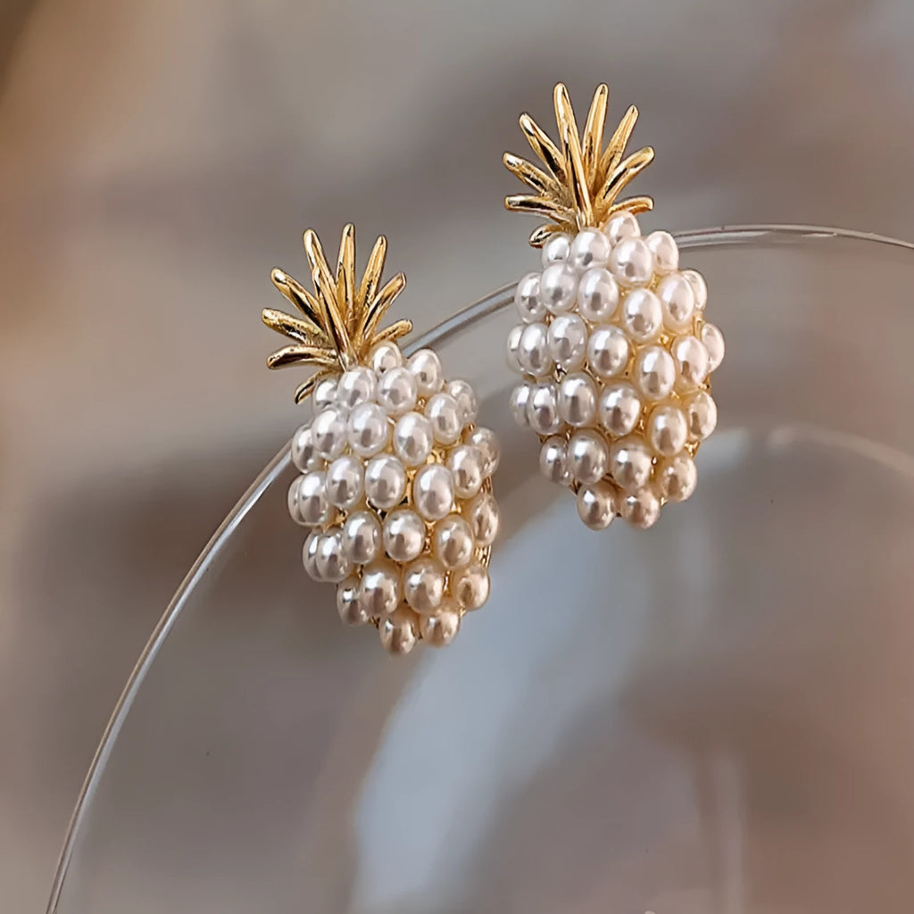 Women's gold electroplated alloy drop earrings with pineapple design and starfish pearl, featuring inlaid stones.
