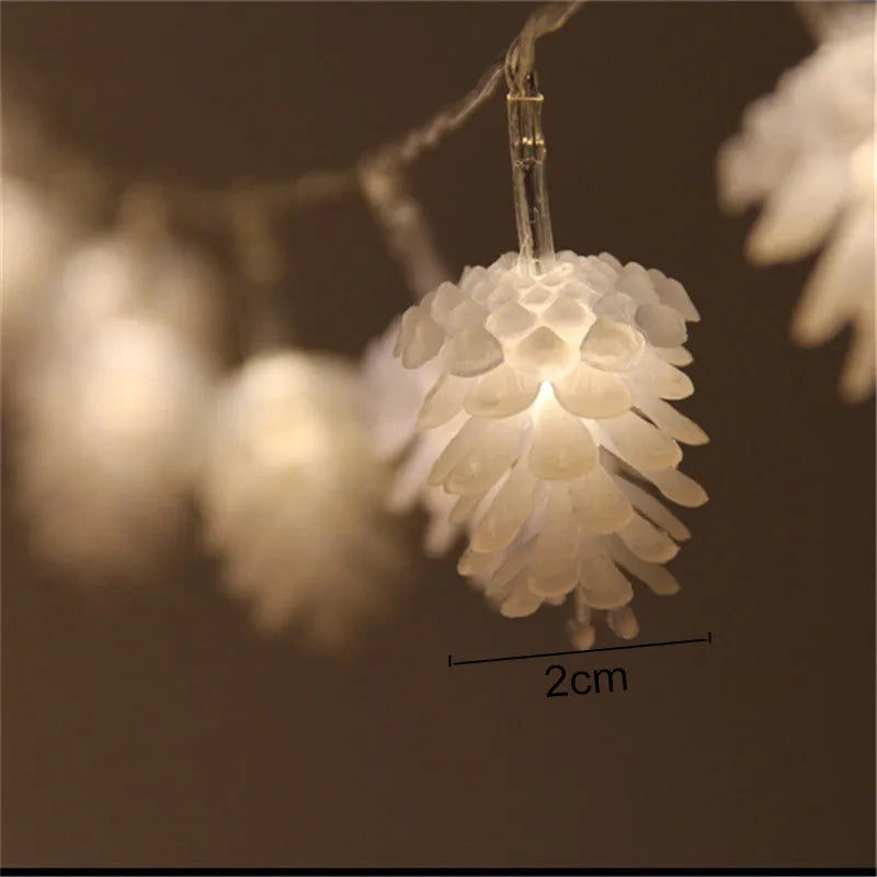 Battery-powered warm white LED pine cone fairy lights draped decoratively on a surface.