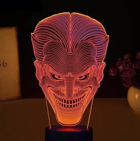 A 3D LED table lamp with a colourful acrylic panel on a square base, showing multiple colour options.