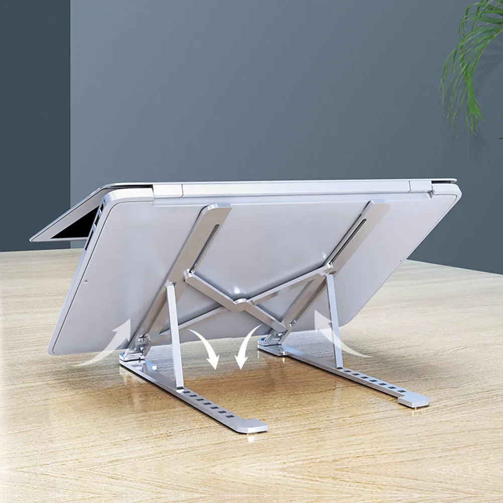 Aluminum foldable laptop stand in silver colour, shown adjusted to an elevated height with a laptop on top.
