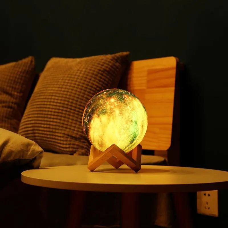 3D printed spherical moon night light with colour changing LED glow on a dark surface.