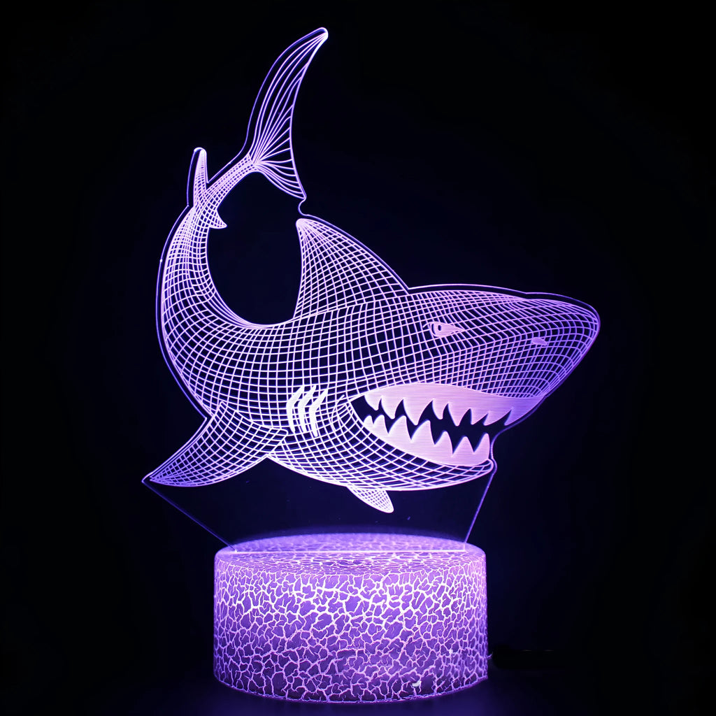 Shark-shaped 3D LED table lamp with colourful lighting on a dark surface