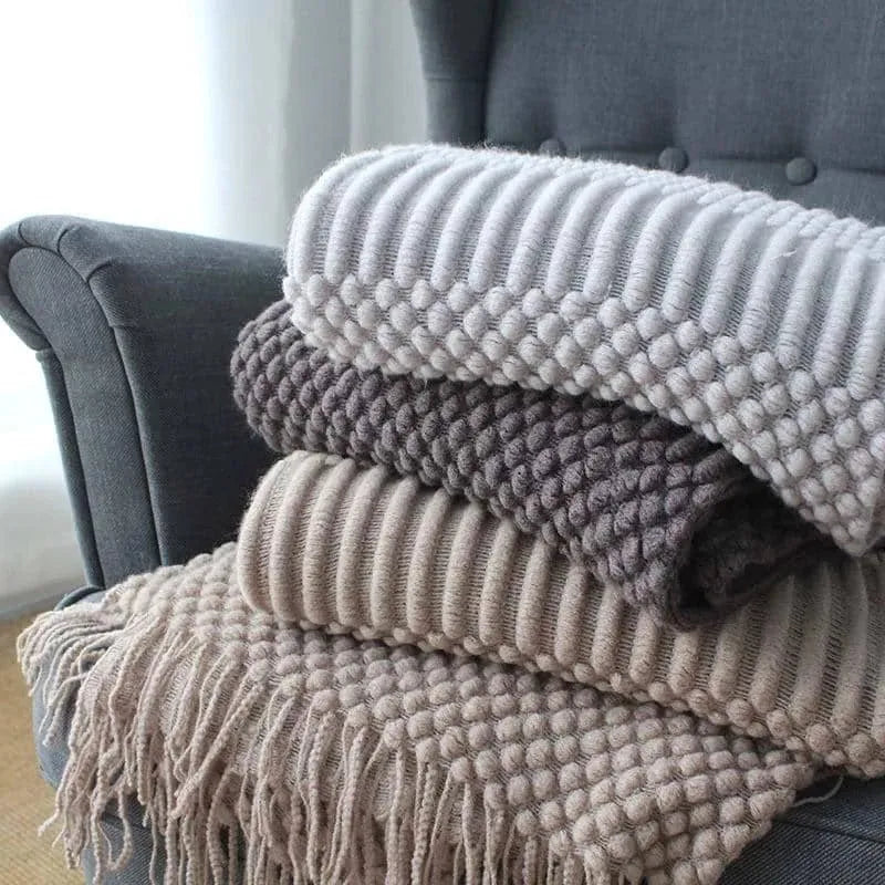 Light grey polyester throw blanket draped over a sofa, showing its size.