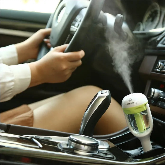 Compact blue car humidifier with rotating nozzle on a car dashboard
